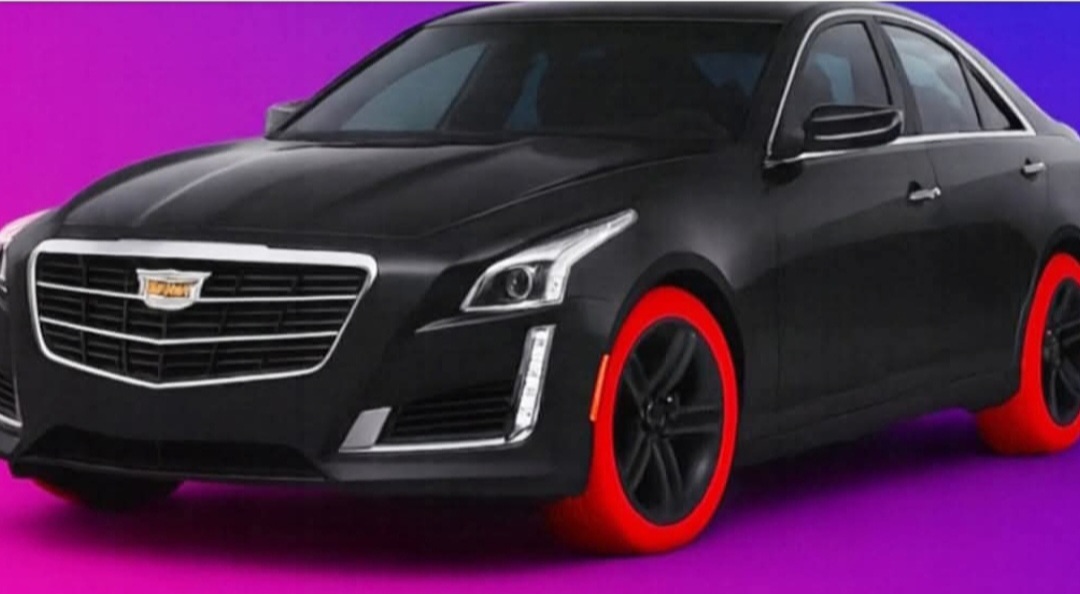 Black Cadillac sedan featuring bold red Adams Designer Tires as a product mock-up concept
